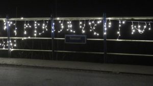 Verlichte brug over de Haansvaart: bordje Haansvaart te midden van de kerstverlichting
